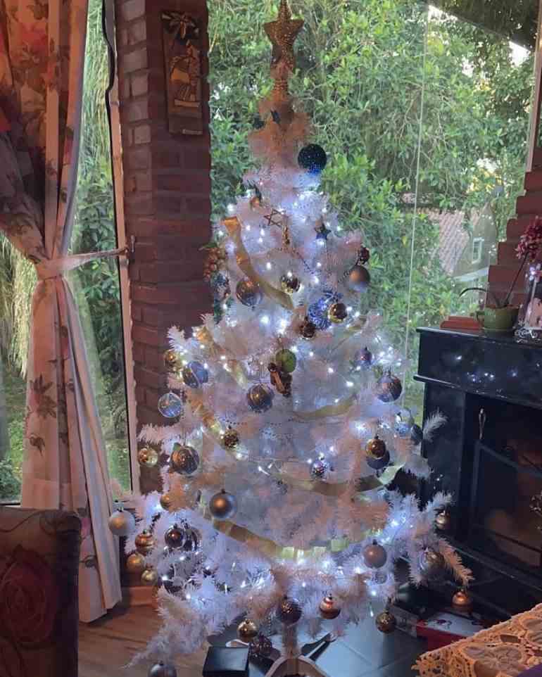Árvore de natal branca com pisca-pisca e estrela dourada