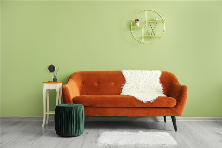 parede verde e sofa laranja
